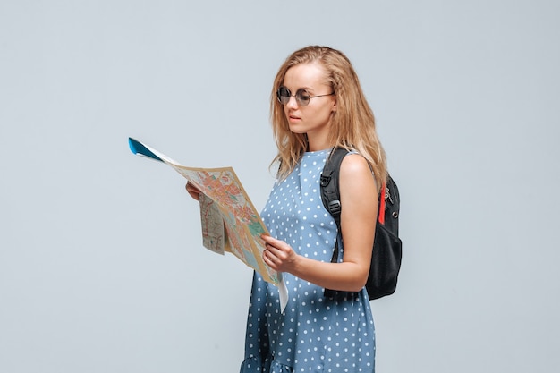 Mädchen Tourist mit einem Rucksack suchen Karte