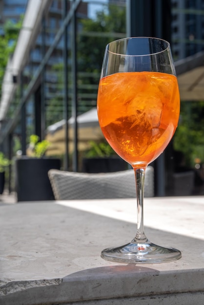 Mädchen trinken eisgekühlten Alkohol Aperol Spritz Cocktail auf der Sommerterrasse im Café oder Restaurant