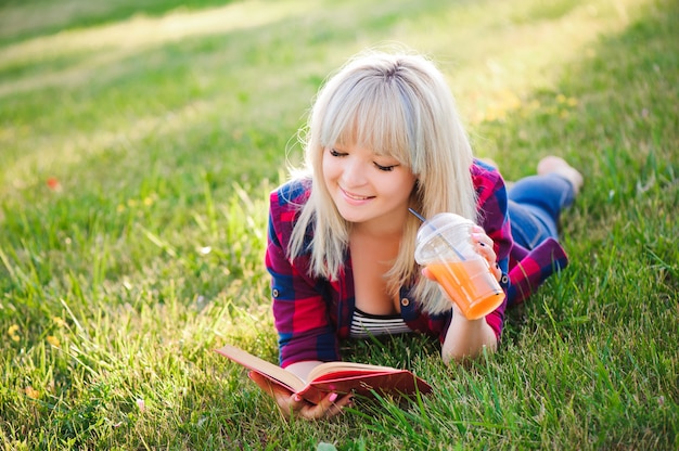 Mädchen trinken Saft und lesen ein Buch in einem Park