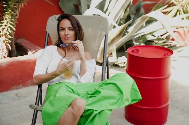 Mädchen trinkt einen Cocktail auf einer Sommerterrasse, Lifestyle-Foto