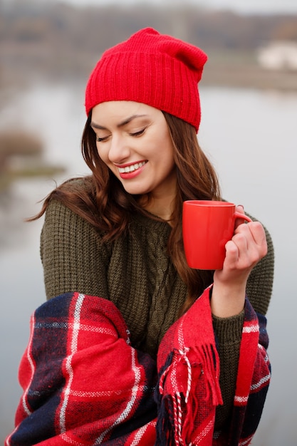 Mädchen trinkt Kaffee von einer roten Tasse