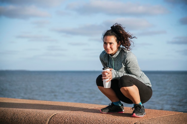 Foto mädchen trinkt wasser am meer