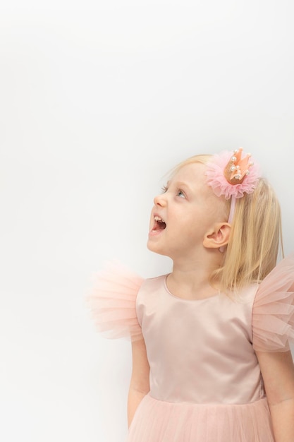 Mädchen überrascht nachschlagen schöne rosa Kleid und Krone Reifen auf dem Kopf Blondehaired Mädchen auf weißem Hintergrund Kopieren Sie Platz