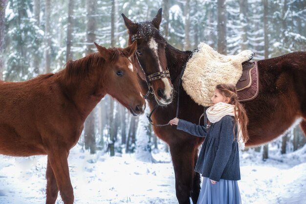 Mädchen und braunes Pferd im Winter in der Natur