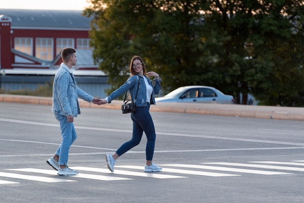 Mädchen und ein Mann überqueren die Straße durch die Hand. Folge mir.