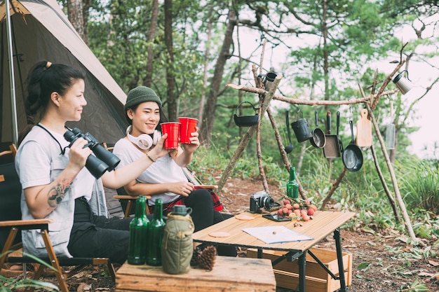 Foto mädchen und freunde, die im wald campen