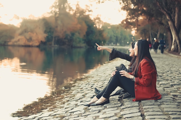 Mädchen und Freundinnen sitzen im Park