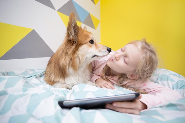 Foto mädchen und hund auf dem bett im kinderzimmer