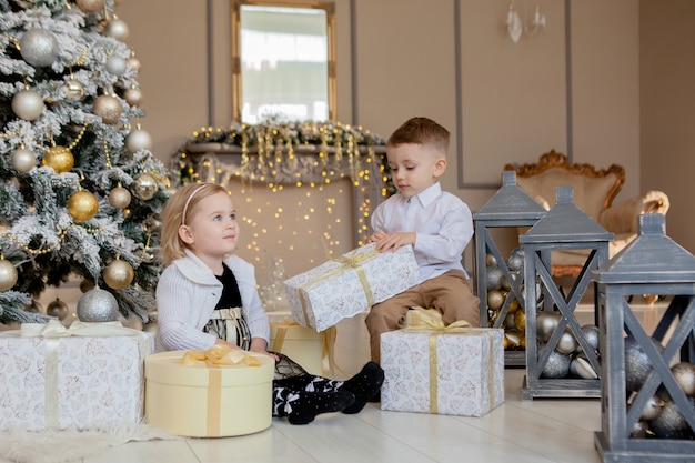 Mädchen und Junge öffnen Weihnachtsgeschenke