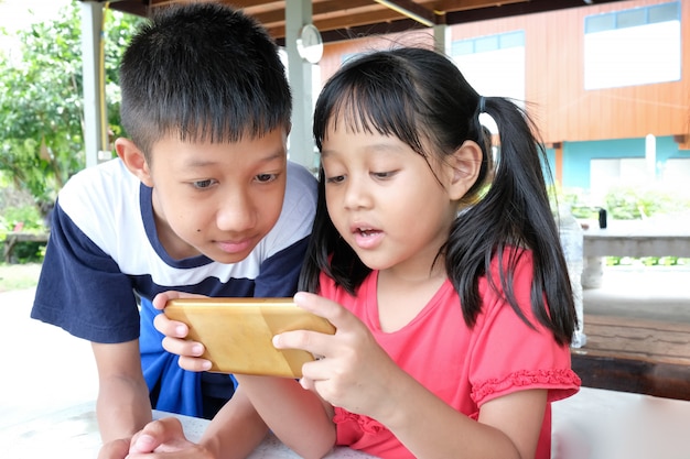 Mädchen und Jungen spielen gerne auf dem Smartphone