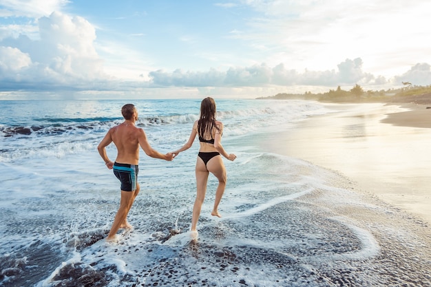 Mädchen und Mann am Strand laufen