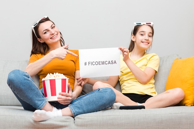 Foto mädchen und mutter auf der couch mit popcorn