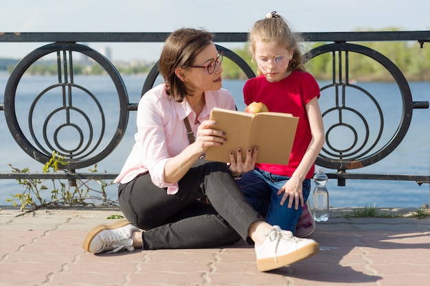 Mädchen und mutter, die das buch lesen