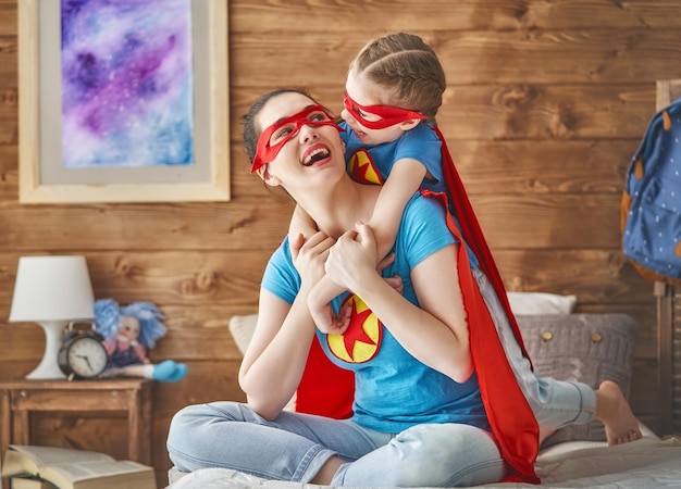 Mädchen und Mutter im Superheldenkostüm