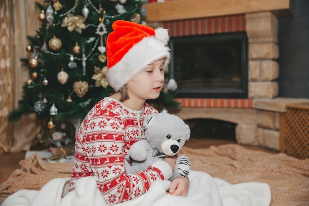 Mädchen und Spielzeug am Weihnachtsbaum im Wohnzimmer