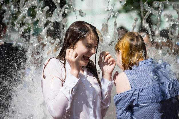 Mädchen unter den Wasserstrahlen Schwimmen im Brunnen Schöne Frau im Regen