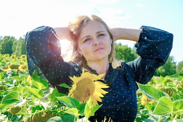 Foto mädchen unter sonnenblumen auf dem feld