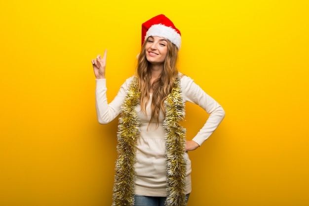 Mädchen, welches die Weihnachtsfeiertage auf gelbem Hintergrund feiert