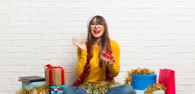 Mädchen, welches die Weihnachtsfeiertage überrascht feiert, weil ein Geschenk gegeben worden ist