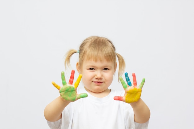 Mädchen zeigt gemalte Hände. Hände in bunten Farben gemalt. Bildungs-, Schul-, Kunst- und Malkonzept