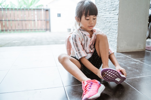 Mädchen zieht ihre Schuhe alleine an