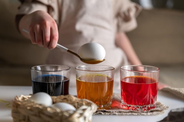 Mädchen zu Hause in der Küche färbt Eier für Ostern