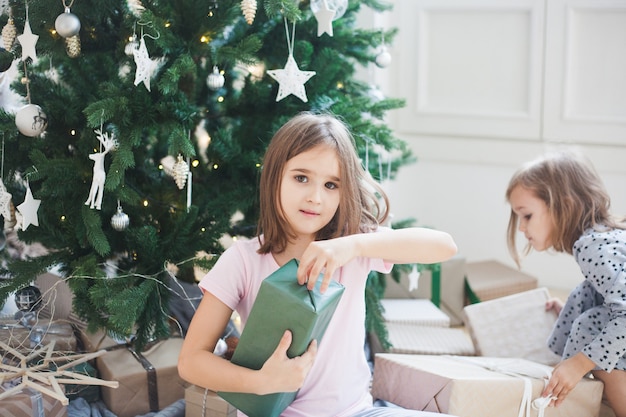 Mädchen zu Hause während Weihnachten mit Baum und Geschenken