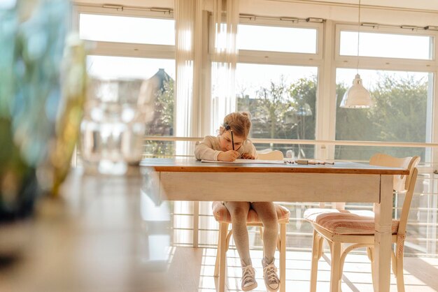 Mädchen zu Hause zeichnet am Tisch