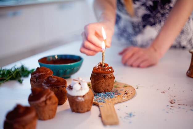 Mädchen zündet die Kerze auf einem Cupcake an