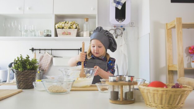 Mädchenbäcker mischt die Mischung für Kekse mit einem Schneebesen aus nächster Nähe