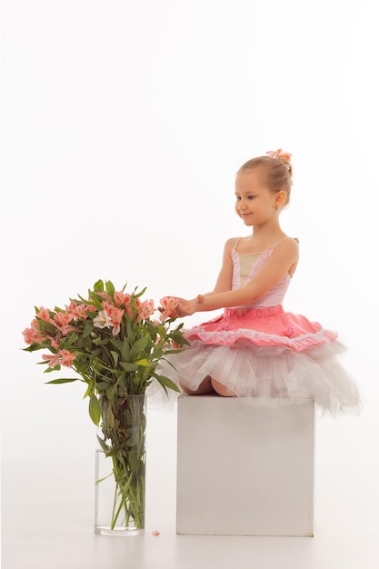 Mädchenballerina in einem Ballettröckchen mit Blumen