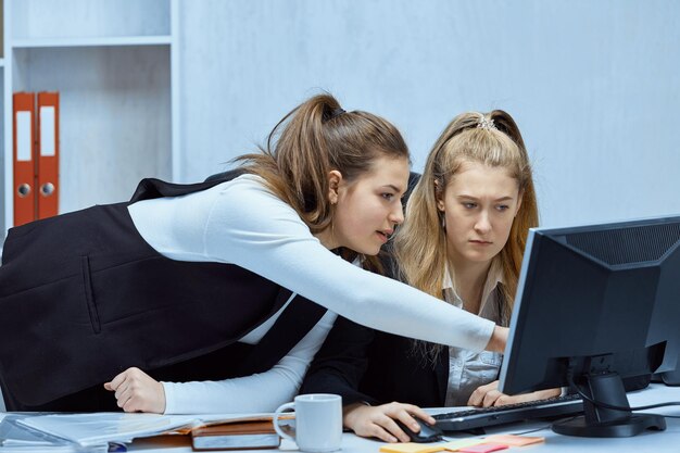 Mädchenbüroangestellte arbeiten an einer gemeinsamen Aufgabe