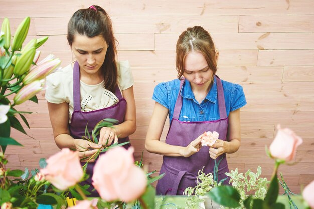 Mädchenfloristen, die im Studio über dem Blumenstrauß arbeiten