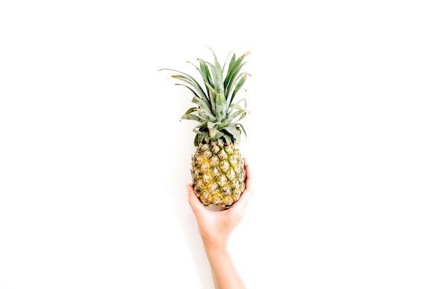 Mädchenhand, die Ananas hält.