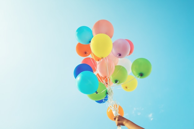 Mädchenhand, die Ballone, Konzept des glücklichen Geburtstags im Sommer hält