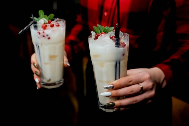 Mädchenkellner mit zwei Milchshakes in der Hand. Foto in hoher Qualität