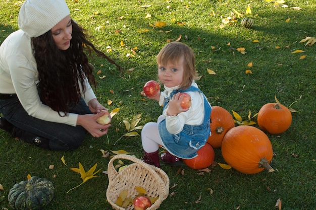 Mädchenkleinkind mit ihrer Mutter im Herbstpark