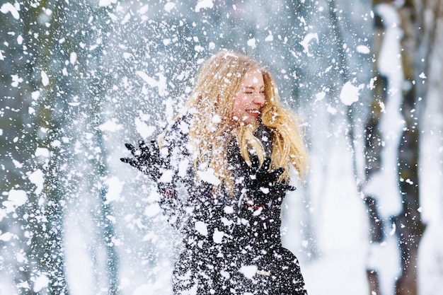 Mädchenporträt des jungen jugendlich des Winters. Schönheits-frohes vorbildliches Girl, das Spaß im Winterpark lacht und hat