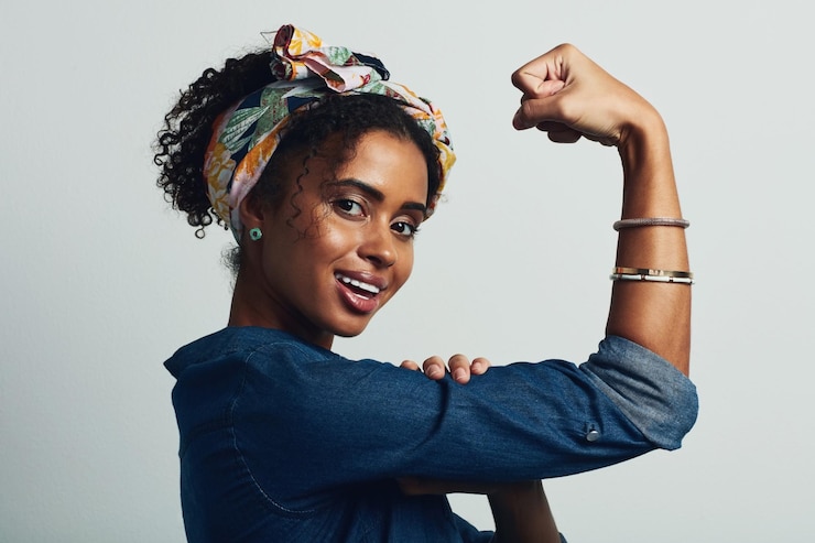 Foto mädchenporträt und stark mit lächeln im studio für frauen stärkung selbstvertrauen und stolz persönlichkeit macht und flex arm mit haltung für feminismus geschlechtergleichheit kampf oder erfolg auf weißem hintergrund
