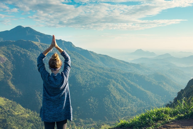 Mädchentourist an der Spitze des Berges in den Strahlen der Morgendämmerung, Sri Lanka