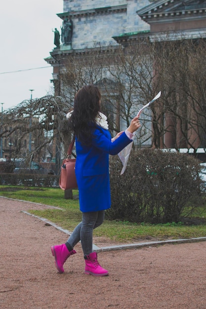 Mädchentourist in der Stadt geht zur erweiterten Karte auf dem Hintergrund eines historischen Gebäudes