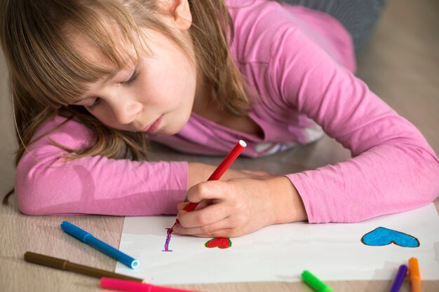 Mädchenzeichnung mit Buntstiften auf weißem Papier