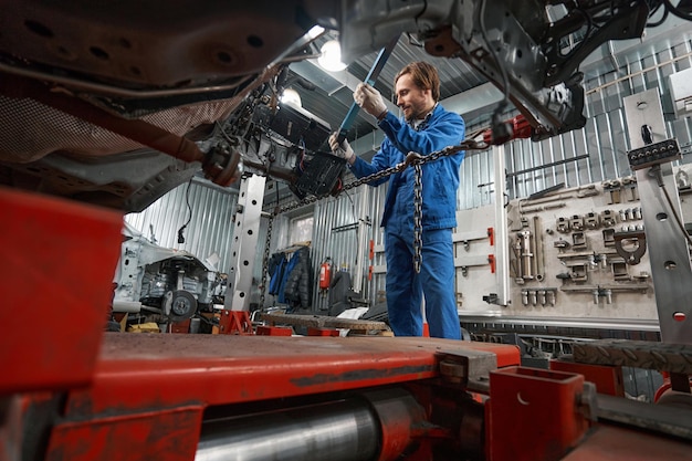 Männchen, das Spezialwerkzeug für die Autoreparatur hält