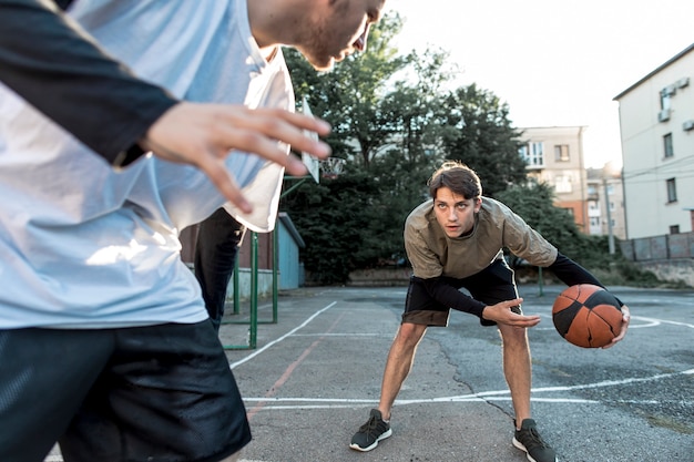 Foto männer, die basketball auf stadtgericht spielen