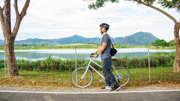 Männer, die Fahrrad nahe einem See bei Singha-Park Chiang Rai, Thailand fahren.