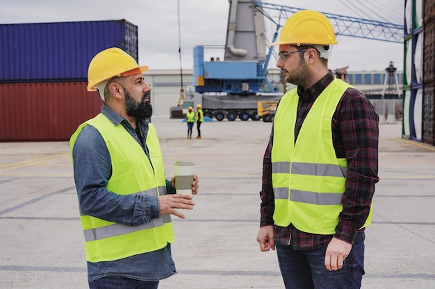 Männer, die im Industriehafen arbeiten und Container kontrollieren