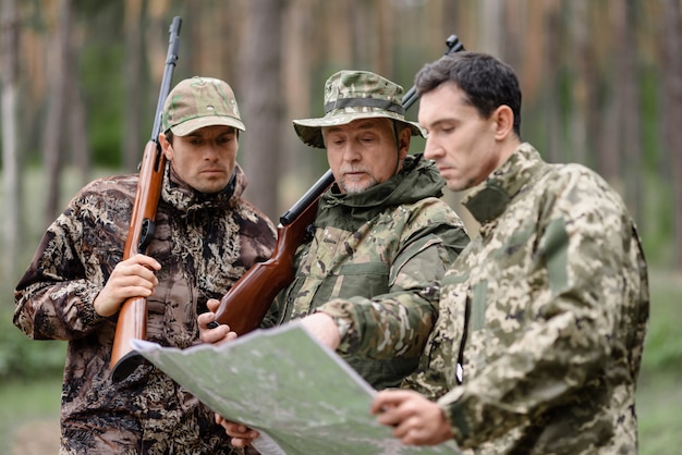 Männer, die Karten-Familien-Jagd in Forest Recreation studieren