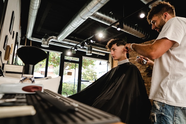 Männer-Friseursalon. Friseur, der Haarschnitt im Friseursalon tut.