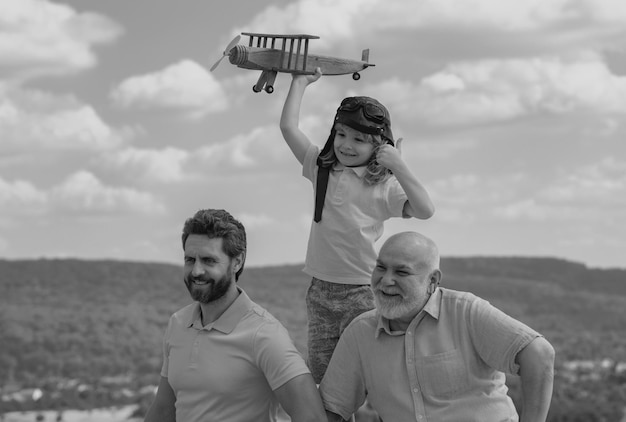 Männer Generation Großvater Vater und Enkel spielen mit Spielzeugflugzeug im Freien am Himmel Junge träumt von b