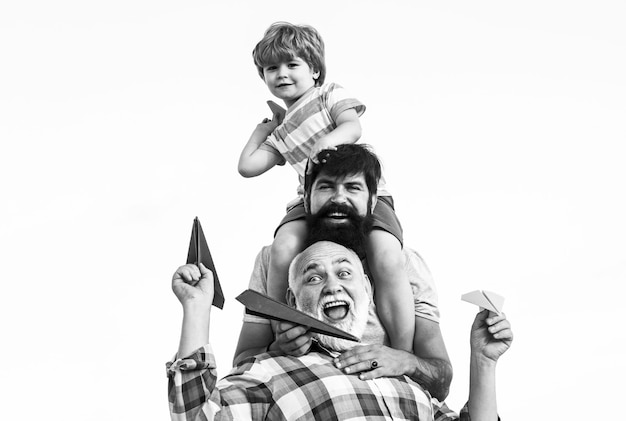 Männer Generation. Kinder spielen mit einfachen Papierflugzeugen am sonnigen Tag. Vater, der Sohn reitet, reitet zurück